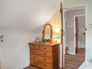 een slaapkamer met een dressoir en een spiegel bij Apple Blossom Cottage - Uk46648 in Cheddar