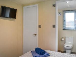 a bathroom with a bed and a toilet and a television at Emilys Escape - Uk46722 in Bridlington