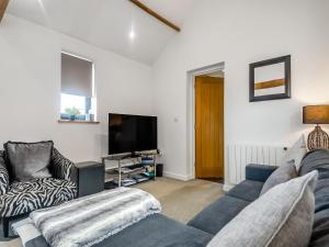 a living room with a couch and a tv at The Barn in Martham