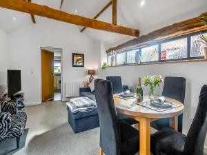 a dining room and living room with a table and chairs at The Barn in Martham