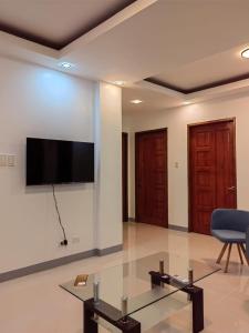 a living room with a flat screen tv on a wall at Michael's Apartment in Moalboal