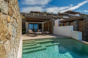 Mykonos Rocks Villas & Suites في مدينة ميكونوس: مسبح في الفناء الخلفي لبيت