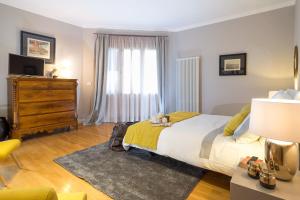 a bedroom with a large bed and a dresser at Penthouse Duomo in Catania