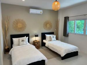 una camera da letto con due letti e una finestra di UMiiMAAN pool villa, 4BR, 4BA a Ko Samui Altre 35 foto