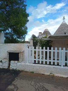 una recinzione bianca di fronte a una casa di Trullo da Nonno Marco a Cisternino