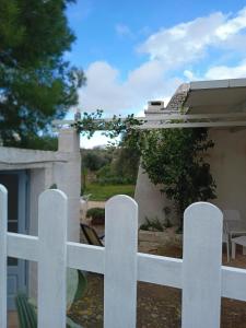una recinzione bianca di fronte a una casa di Trullo da Nonno Marco a Cisternino