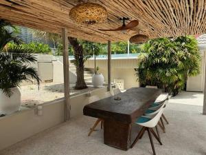 una sala da pranzo con tavolo in legno e alcune piante di UMiiMAAN pool villa, 4BR, 4BA a Ko Samui
