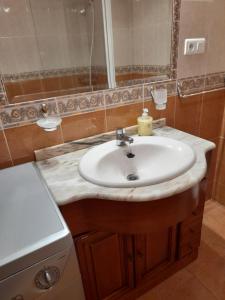 uma casa de banho com um lavatório branco e um espelho. em Carmina fondon 3 em Cangas de Onís