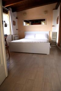 a bedroom with a white bed and a wooden floor at A Casa Di Eta in Gaeta
