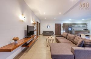 - un salon avec un canapé et une télévision dans l'établissement A comfy 2BR home with Balcony Views in Kalkara by 360 Estates, à Kalkara
