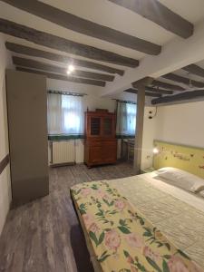 a bedroom with a bed and a dresser and windows at Borgo degli Ulivi in Crespellano
