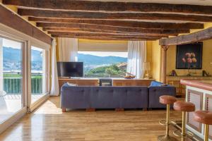 a living room with a blue couch and a large window at COSTA BRAVA SUITES Villa Bonavida in Sant Feliu de Guixols