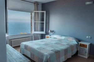 a bedroom with a bed and a window with the ocean at COSTA BRAVA SUITES Villa Bonavida in Sant Feliu de Guixols +25 photos
