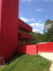 um edifício vermelho ao lado de uma cerca vermelha em Pousada Maria Francisca em Santa Bárbara