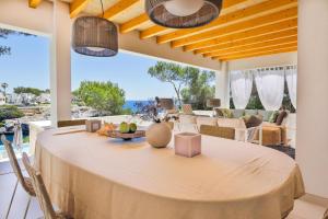 a dining room with a table with a view of the ocean at Vista DOr in Cala d´Or