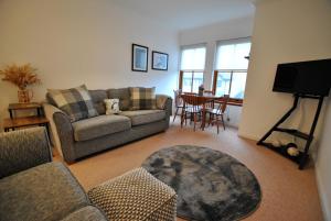 sala de estar con sofá y mesa en Meadowshores Apartment Crail, en Crail