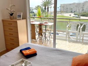 a bedroom with a bed and a balcony with a table at APARTBEACH ARRECIFE y FRENTE PLAYA in La Pineda
