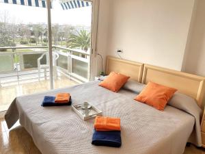 a bedroom with a bed with orange and blue pillows at APARTBEACH ARRECIFE y FRENTE PLAYA in La Pineda
