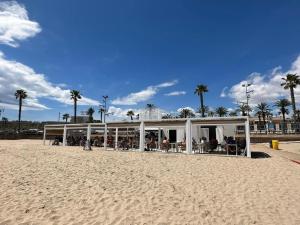 a building on the beach next to the sand at APARTBEACH ARRECIFE y FRENTE PLAYA in La Pineda