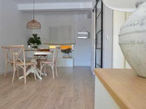 eine Küche und ein Esszimmer mit einem Tisch und Stühlen in der Unterkunft Apartamento Chic Sagaró in S'Agaró
