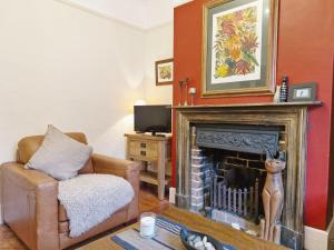 a living room with a chair and a fireplace at Tern Cottage in Bognor Regis