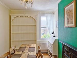a dining room with a table and chairs and a window at Tern Cottage in Bognor Regis