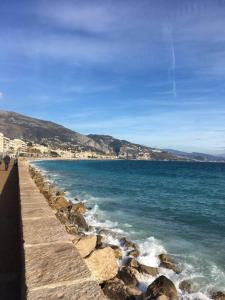 uma vista para o oceano com pessoas caminhando na praia em Holiday rental in Roquebrune Cap Martin em Roquebrune-Cap-Martin