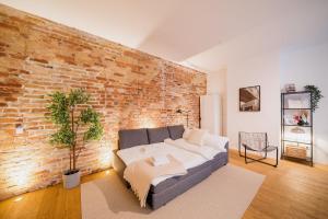 a living room with a couch and a brick wall at Urban Retreat - City Center Apartment in central Berlin BY HOMELY in Berlin
