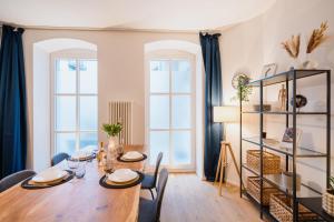 a dining room with a table and two windows at Urban Retreat - City Center Apartment in central Berlin BY HOMELY in Berlin