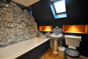 a bathroom with a tub and a toilet and a sink at The House on the Square- Coastal Townhouse in Saint Monance +37 photos