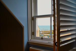 a window with a view of the ocean at The House on the Square- Coastal Townhouse in Saint Monance