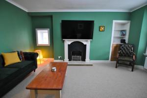 a living room with a couch and a fireplace at The House on the Square- Coastal Townhouse in Saint Monance