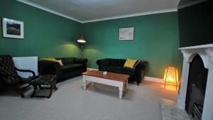 a living room with two couches and a coffee table at The House on the Square- Coastal Townhouse in Saint Monance