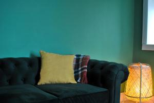 a couch with a pillow and a lamp in a room at The House on the Square- Coastal Townhouse in Saint Monance