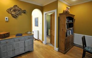 a room with a wooden cabinet and a book shelf at The House on the Square- Coastal Townhouse in Saint Monance