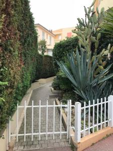 uma cerca branca em frente a um jardim em Holiday rental in Roquebrune Cap Martin em Roquebrune-Cap-Martin