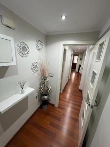 a hallway of a home with white walls and wooden floors at Magnífico alojamiento cerca de, Mezquita catedral in Córdoba