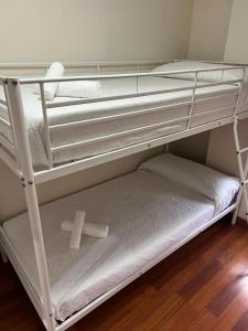 a bunk bed with a cross on the bottom shelf at Magnífico alojamiento cerca de, Mezquita catedral in Córdoba