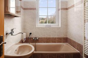 a bathroom with a tub and a window at Hotel Adršpach in Adršpach