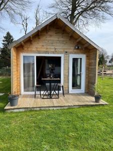 eine kleine Holzhütte mit einem Tisch auf einer Terrasse in der Unterkunft Les gîtes d'Aloziwen le TY BARVEK in Bordeaux-Saint-Clair
