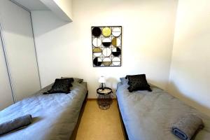 two twin beds in a room with a window at Les Naïades D15- 2 bedrooms for 5 people ! in Avène