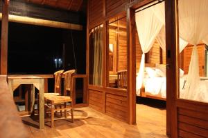 1 dormitorio con 1 cama, mesa y sillas en Manuk Dewata Villa, en Sidemen