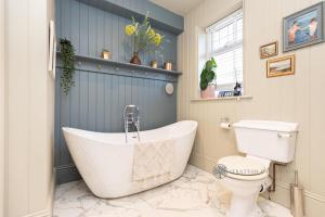 uma casa de banho com banheira e WC em Luxury Christchurch Retreat em Iford