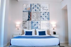 um quarto com uma cama grande e almofadas azuis em Rio Art Hotel em Setúbal