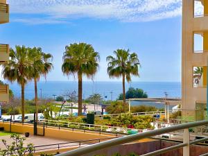 vistas al océano desde un edificio con palmeras en Lovely beachfront apartment with Aircon/WIFI, en Portimão