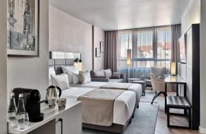 pokój hotelowy z łóżkiem i kanapą w obiekcie Leonardo Royal Hotel Warsaw w Warszawie
