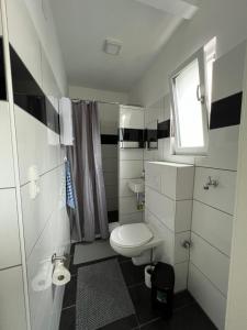 uma pequena casa de banho branca com um WC e uma janela em Ferienwohnung ENJOY 2 em Goslar