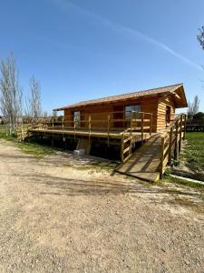 uma cabana de madeira com uma rampa que conduz a um edifício em Alojamiento Rural La Alberca em Arguedas
