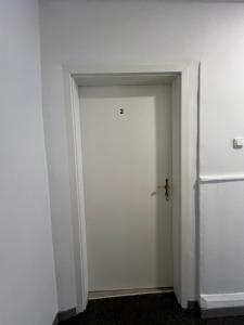Una puerta blanca en una habitación con nevera. en Ferienwohnung ENJOY 2 en Goslar