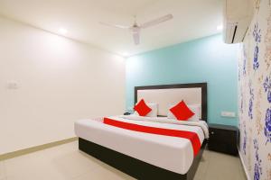 a bedroom with a large bed with red pillows at OYO My Comfortable Hotel in New Delhi